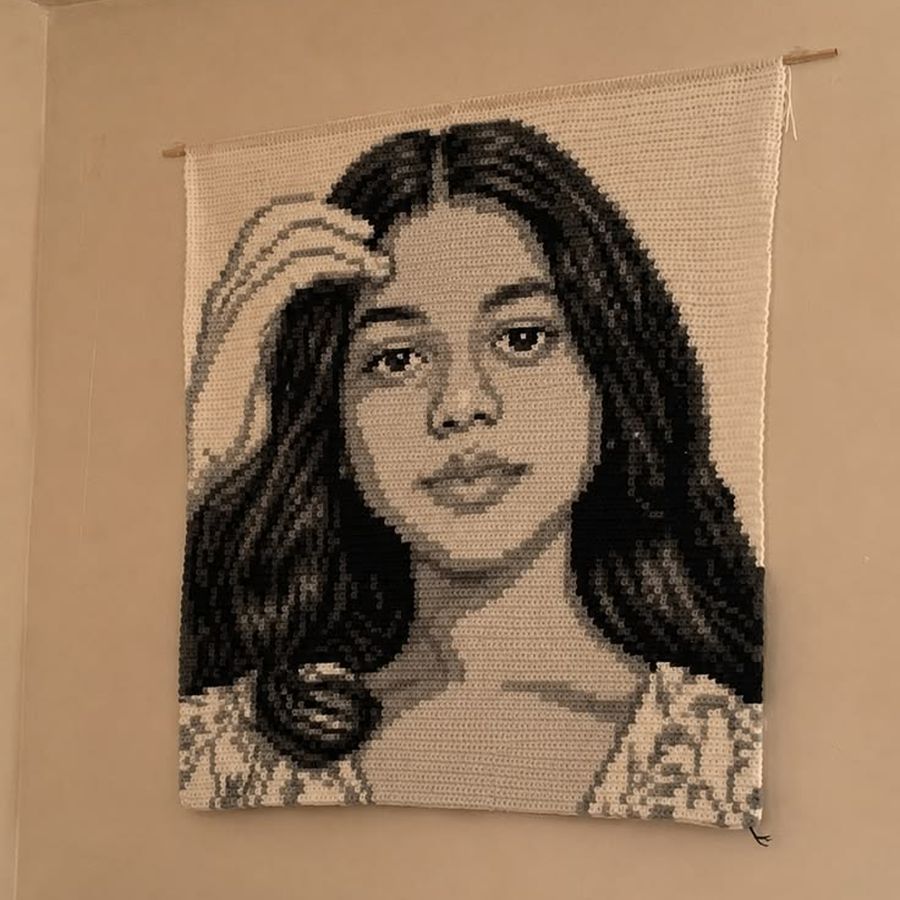 Retrato de una mujer hecho en crochet, colgado en la pared